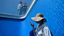 Orang-orang mengunjungi karya seni Swimming Pool dalam sebuah pameran di Museum CAFA, Beijing, 23 Juli 2019. Bagian atas karya seni unik itu berlapis kaca transparan yang dilapisi air sedalam 10 cm, sedangkan bagian bawahnya merupakan ruang kosong dengan dinding berwarna biru muda. (WANG Zhao/AFP)
