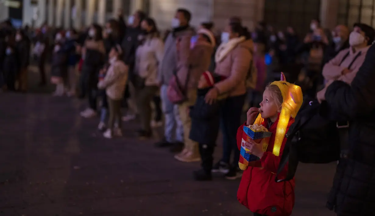 Seorang anak menikmati pertunjukan Natal di pusat kota Madrid, Spanyol, Rabu (22/12/2021). PM Spanyol Pedro Sanchez mengadakan rapat Kabinet khusus untuk mengesahkan undang-undang yang mewajibkan penggunaan masker di luar ruangan di tengah lonjakan rekor kasus COVID-19. (AP Photo/Manu Fernandez)