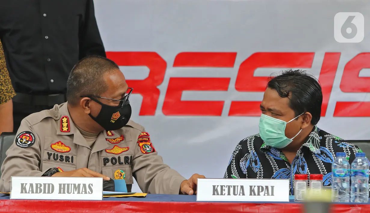 Kabid Humas Polda Metro Jaya Kombes Pol Yusri Yunus berbincang dengan  Ketua Komisi Perlindungan Anak (KPAI) Susanto saat  gelar kasus prostitusi dan eksploitasi anak di Ditreskrimum Polda Metro Jaya, Jakarta, Jumat (19/03/2021). (Liputan6.com/Herman Zakharia)