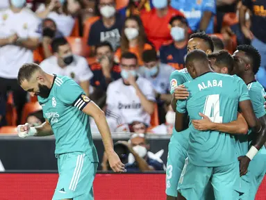 Penyerang Real Madrid Vinicius Junior berselebrasi dengan rekan setimnya setelah mencetak gol ke gawang Valencia pada lanjutan La Liga di Stadion Mestalla, Senin (20/9/2021) dini hari WIB. Real Madrid menang 2-1 secara dramatis atas Valencia. (AP Photo/Alberto Saiz)