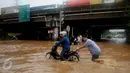 Warga membantu mendorong motor yang mogok saat berusaha menerobos banjir di Jalan Raya Kalimalang, Caman, Bekasi, Senin (20/2). Banjir setinggi 80 cm itu disebabkan drainase buruk & diperparah tingginya intensitas curah hujan (Liputan6.com/Gempur M Surya)