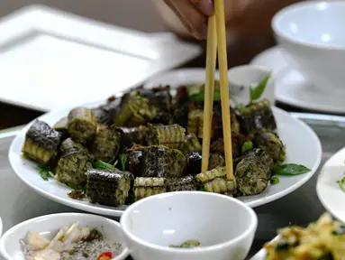 Foto pada 24 Agustus 2018 memperlihatkan pelanggan menyantap olahan daging ular di sebuah restoran khusus provinsi Yen Bai, Vietnam. Daging ular menempati peringkat pertama sebagai hidangan ekstrem yang digemari banyak orang Vietnam. (AFP/Nhac NGUYEN)