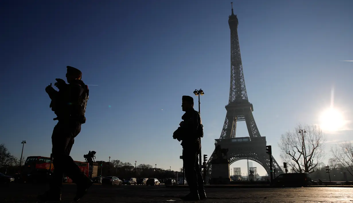 Polisi anti huru-hara berpatroli di dekat Menara Eiffel di Paris,  Senin (30/12/2019). Pemerintah Prancis akan mengerahkan 100.000 petugas polisi untuk mengamankan ruang publik pada perayaan malam Tahun Baru di tengah aksi mogok yang sedang berlangsung. (AP/Christophe Ena)