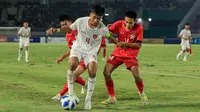 Kapten Timnas Indonesia U-16, Putu Panji berduel dengan pemain Laos pada laga matchday ketiga Grup A Piala AFF U-16 2024 di Stadion Manahan, Solo. (Bola.com/Radifa Arsa)