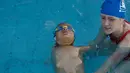 Ismail Zulfic melakukan latihan dibantu pelatih renangnya di kolam renang Olimpiade di Sarajevo, Bosnia (8/6). Ismail Zulfic yang baru berusia enam tahun ini sanggup berenang di kolam renang taraf olimpiade meskipun tanpa lengan. (AP Photo/Amel Emric)
