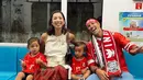 Nonton bola bersama keluarga, Jennifer Bachdim memilih mengenakan busana etnik namun tetap dengan nuansa merah putih. Sementara Irfan dan buah hati mereka kompak kenakan jersey timnas merah. [@jenniferbachdim].