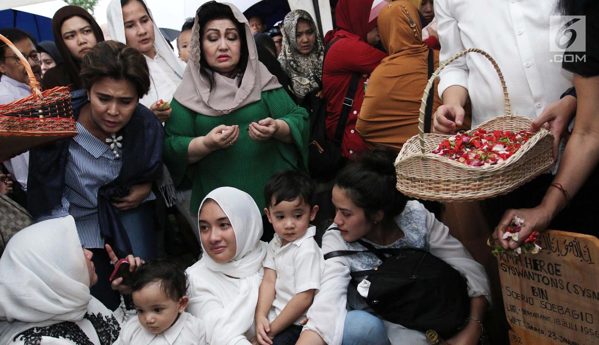 Penyanyi Ernie Djohan saat berdoa di pusara makam almarhum RMH Heroe Siswanto atau dikenal Sys NS usai pemakaman di TPU Jeruk Purut, Jakarta, Selasa (23/1). (Liputan6.com/Herman Zakharia)