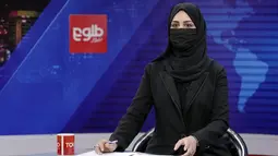 Khatereh Ahmadi, seorang presenter televisi mengenakan penutup wajah saat membacakan berita di TOLO NEWS, di Kabul, Afghanistan, Minggu, 22 Mei 2022. Taliban mulai mewajibkan semua presenter atau pembawa acara televisi perempuan menutupi wajah mereka saat siaran. (AP Photo/Ebrahim Noroozi)