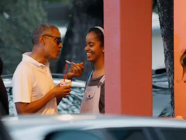 Presiden AS, Barack Obama berbincang dengan putri sulungnya, Malia sambil menikmati es serut saat libur Natal di Kailua, Hawai, AS, (24/12). Obama dan keluarganya akan berlibur selama 17 hari hingga awal Januari 2017. (REUTERS/Kevin Lamarque)