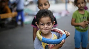 Seorang anak lelaki tampak tengah bermain di kamp pengungsi Sekolah PBB di Jabalia, Gaza (28/7/14). (AFP PHOTO/MOHAMMED ABED)