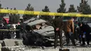 Anggota keamanan Afghanistan memeriksa sebuah mobil yang rusak di jalanan Ibu Kota Afghanistan, Kabul, Rabu (28/12). Ledakan bom mengguncang kendaraan anggota parlemen dan menyebabkan tiga orang mengalami luka-luka. (WAKIL KOHSAR/AFP)