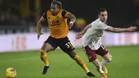 Penyerang Wolverhampton Wanderers, Adama Traore berebut bola dengan bek Arsenal, Cedric Soares pada pekan ke-22 Liga Inggris di stadion Mollineux, Rabu (3/2/2021) dini hari WIB. Arsenal harus pulang dengan tangan hampa usai kalah 1-2 atas Wolverhampton.  (Shaun Botterill/Pool via AP)