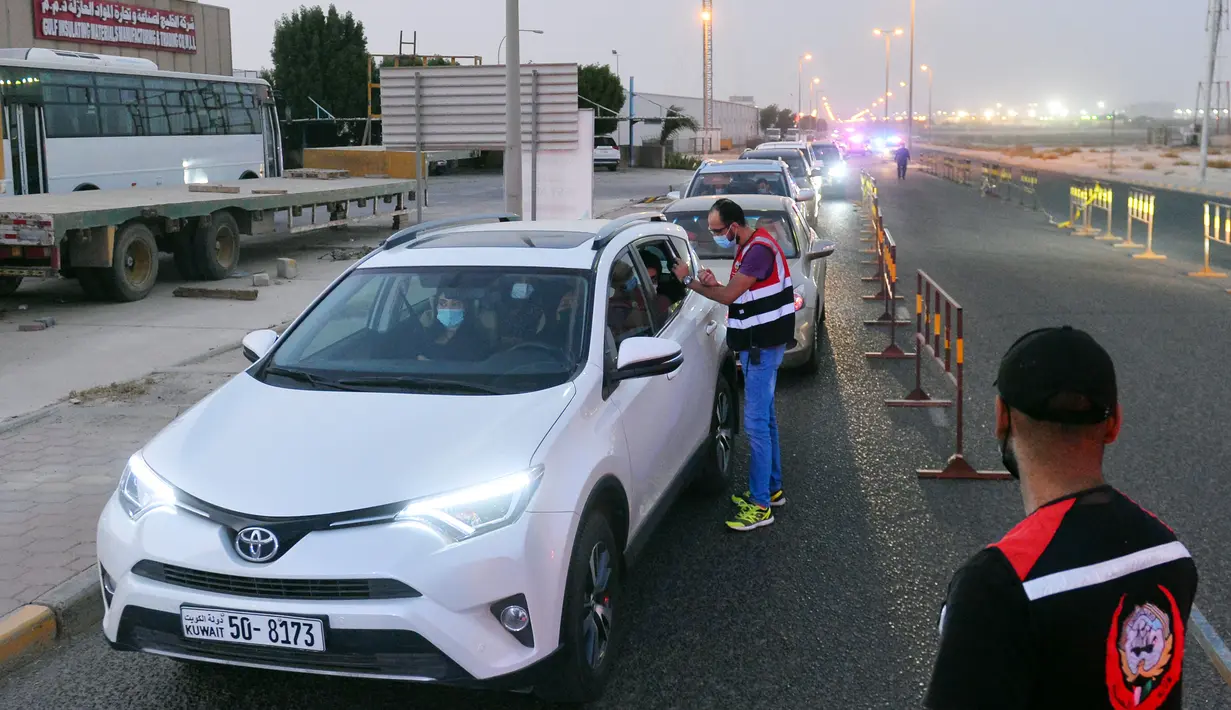 Petugas medis mendata orang-orang yang antre memasuki sebuah stasiun pengujian lantatur (drive thru) baru untuk COVID-19 di Kegubernuran Mubarak Al-Kabeer, Kuwait, 20 September 2020. Kuwait membuka stasiun pengujian PCR lantatur baru untuk memperluas kapasitas pengujian COVID-19. (Xinhua/Asad)