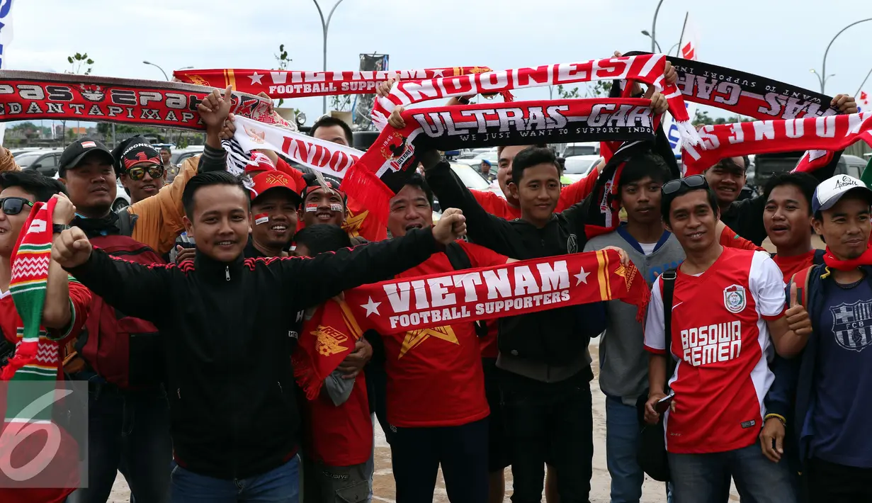 Suporter Timnas Vietnam berfoto bersama pendukung Indonesia jelang memasuki Stadion Pakansari, Bogor, Sabtu (3/12). Timnas Vietnam akan melakoni laga tandang semifinal pertama Piala AFF 2016 melawan Indonesia. (Liputan6.com/Helmi Fithriansyah)