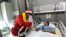 Seorang pria mengenakan kostum Santa Claus membagikan bingkisan Natal kepada pasien yang dirawat di RS Siloam, TB Simatupang, Jakarta, Kamis (21/12). Kegiatan ini dalam rangka menyambut perayaan Hari Natal 2017. (Liputan6.com/Joan)
