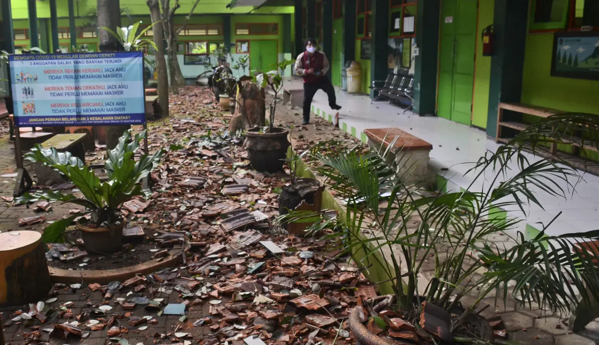 Potongan-potongan genteng dan puing-puing lainnya berserakan di tanah sebuah sekolah setelah gempa bumi di Malang, Jawa Timur, Sabtu (10/4/2021). Gempa bumi yang kuat merusak bangunan di pulau utama Indonesia di Jawa dan mengguncang tempat wisata di Bali, kata pejabat. (AP Photo/Hendra Permana)