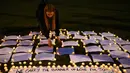 Seorang wanita menyalakan lilin untuk mengenang kematian anggota parlemen Inggris, Jo Cox di Parliament Square, London, Kamis (16/6). Muncul dugaan Jo Cox dihabisi dipicu persiapan referendum Inggris meninggalkan Uni Eropa. (REUTERS/Neil Hall)
