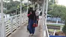 Sejumlah warga melintasi jembatan penyeberangan orang di Jakarta, Minggu (6/8). Dinas Bina Marga DKI Jakarta pada tahun ini akan merevitalisasi JPO yang sudah tua di Ibu Kota. (Liputan6.com/Immanuel Antonius)