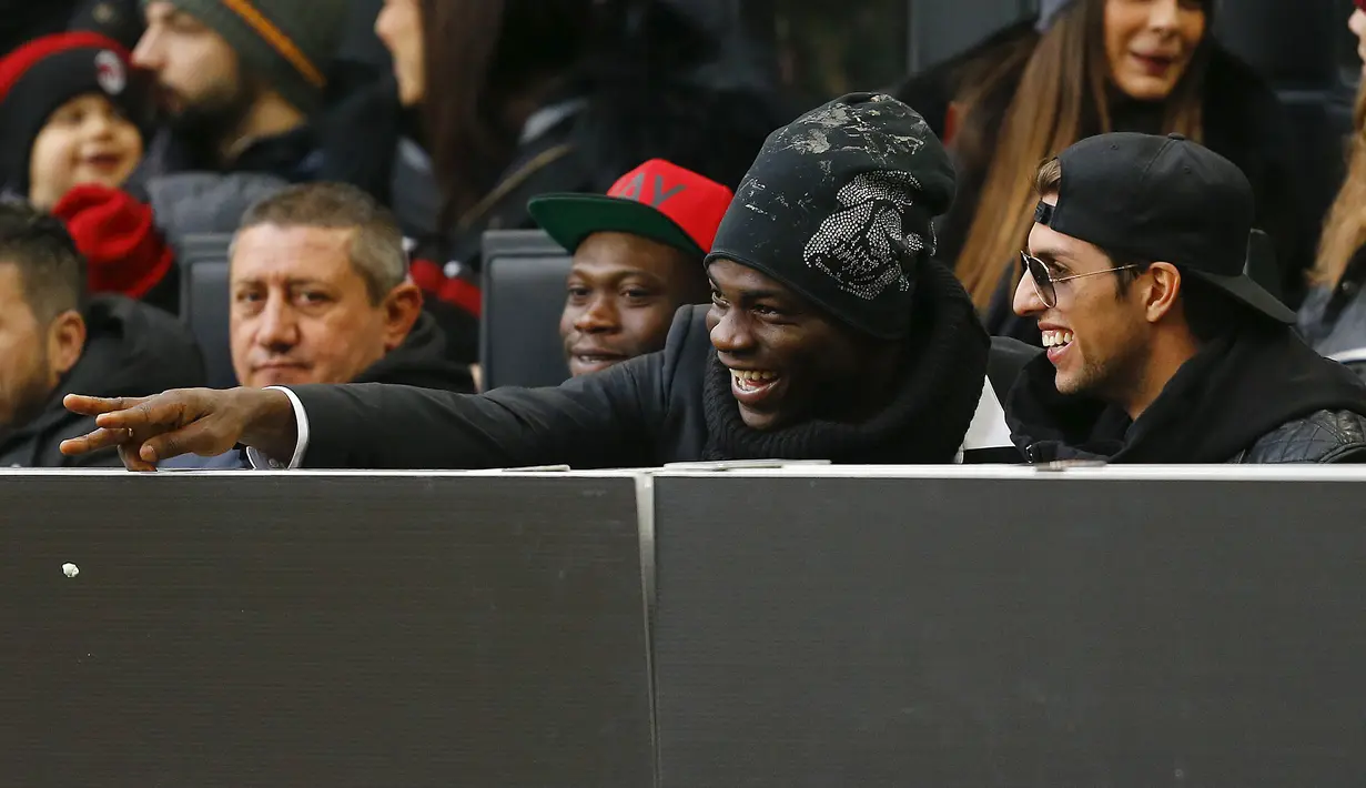 Penyerang AC Milan, Mario Balotelli (kedua kanan) saat menyaksikan rekan-rekannya bertanding melawan Bologna pada laga liga italia di Stadion San Siro, Milan, Italia (7/1/2016). Bolagna menang atas AC Milan dengan skor 1-0. (REUTERS/Stefano Rellandini)