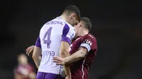 Bek Fiorentina, Nikola Milenkovic (kiri) menanduk striker Torino, Andrea Belotti dalam laga lanjutan Liga Italia 2020/21 pekan ke-20 di Olympico Grande Stadium, Jumat (29/1/2021). Fiorentina bermain imbang 1-1 dengan Torino. (LaPresse via AP/Fabio Ferrari)