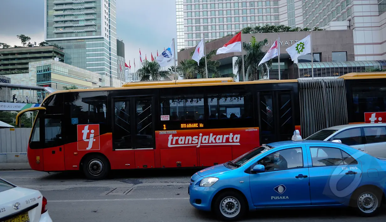 Bus TransJakarta melewati kawasan Bundaran HI, Jakarta, Senin (9/3/2015). PT Transjakarta menghentikan operasional 30 bus merek Zhongtong pasca insiden terbakarnya bus buatan Tiongkok itu pada Minggu (8/3) kemarin. (Liputan6.com/Faizal Fanani)