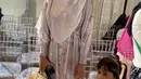 Kartika Putri tampil dengan dress SHI bermotif yang dipadukan kerudung putih dengan bros Chanelnya.