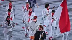 Kontingen Indonesia mengikuti defile dalam pembukaan Olimpiade Tokyo 2020, di Stadion Nasional Jepang, Tokyo, Jumat malam (23/7/2021). Kontingen Indonesia tampil gagah dalam upacara pembukaan Olimpiade Tokyo. (Ben STANSALL/AFP)