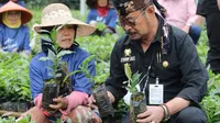 Mentan Syahrul Yasin Limpo (SYL) bersama salah satu petani lokal Garut, saat meninjau nursey bibit kopi di Desa Cikandang, Kecamatan Cikajang, Garut, Ahad (28/8/2022). (Liputan6.com/Jayadi Supriadin)