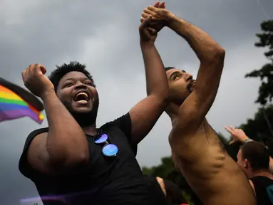 Dua pria menari saat mengikuti parade ‘Gay Pride’ di Berlin, Jerman, Sabtu (22/7). Pendukung gay dan lesbian berpesta setelah Parlemen Jerman melegalkan pernikahan sesama jenis. (AP/Markus Schreiber)