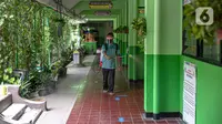 Seorang guru mendisinfeksi SDN Kenari 08, Jakarta, Selasa (6/4/2021). Uji coba pembelajaran tatap muka terbatas di DKI Jakarta akan dilakukan dengan menerapkan protokol kesehatan COVID-19 yang ketat. (Liputan6.com/Faizal Fanani)