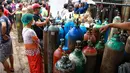 Orang-orang mengantre  untuk mengisi ulang tabung oksigen di luar pabrik oksigen Naing di zona industri South Dagon di Yangon, Myanmar, Rabu (28/7/2021). Myanmar saat ini dilanda lonjakan jumlah kasus COVID-19 dan kematian yang sangat membebani infrastruktur medis negara itu. (AP Photo)