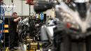 Pekerja mengencangkan baut bagian depan sepeda motor Triumph di pabriknya di Hinckley, Inggris (2/10). Pada tahun 1902 Triumph berkembang memproduksi sepeda motor pertama, Triumph 1. (AFP Photo/Oli Scarff)