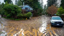 Jalanan berlumpur di lingkungan Felton Grove, Felton, California, Amerika Serikat, 10 Januari 2023. Serangkaian badai yang menghantam California telah menyebabkan jalanan terendam banjir, gelombang tinggi air laut, sungai meluap, dan memaksa ribuan orang untuk mengungsi. (AP Photo/Nic Coury)