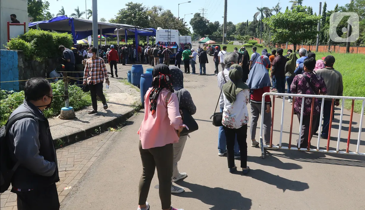 Warga mengantre untuk pembuatan dan memperpanjang SIM di mobil layanan SIM Keliling Masjid At-Tin TMII, Jakarta Timur, Kamis (4/6/2020). Direktorat Lalu Lintas Polda Metro Jaya mengoperasikan kembali layanan mobil SIM Keliling untuk mengantisipasi antrean pemohon. (Liputan6.com/Herman Zakharia)