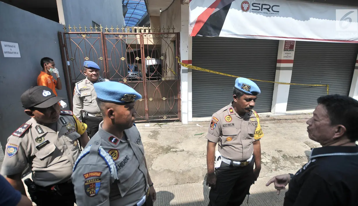 Polisi berjaga di tempat kejadian perkara (TKP) pembunuhan satu keluarga di Bojong Nangka II, Bekasi, Jawa Barat, Rabu (21/11). Pelaku melakukan 37 adegan dalam rekonstruksi. (Merdeka.com/Iqbal Nugroho)