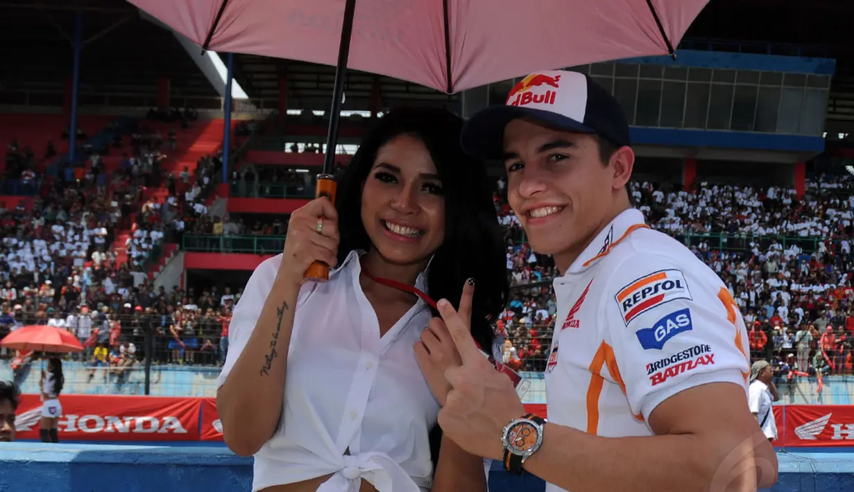 Marc Marquez (kiri) berpose bersama salah satu gadis payung saat berlangsungnya acara Meet & Greet di Sirkuit Sentul, Bogor, (21/10/2014). (Liputan6.com/Helmi Fithriansyah)