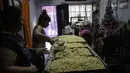 Perempuan menyiapkan makanan gratis untuk tetangga dan orang-orang yang bekerja di daur ulang, di tempat makan malam populer yang disebut "Cartoneritos," di pinggiran Buenos Aires, Argentina (14/12/2021). (AP Photo/Rodrigo Abd)