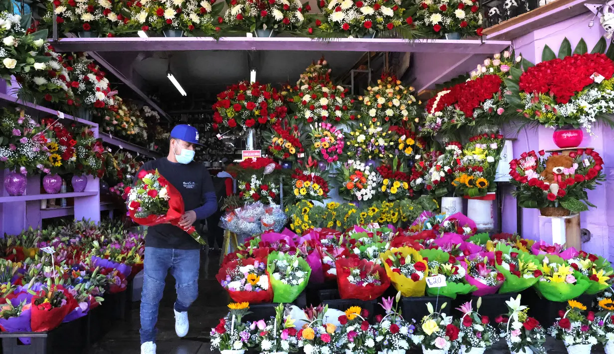Seorang pekerja membawa karangan bunga di distrik bunga dua hari sebelum Hari Valentine di tengah pandemi COVID-19 di Los Angeles, California (12/2/2021).  Jumlah kematian akibat virus corona di AS lebih dari 450.000.  (Mario Tama/Getty Images/AFP)