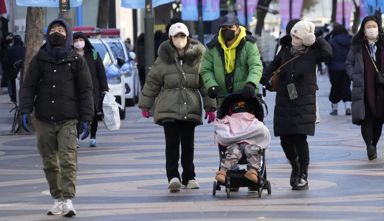Orang-orang berjalan dalam suhu yang sangat dingin di sepanjang jalan di Seoul, Korea Selatan, Rabu (25/1/2023). Suhu ekstrem tidak hanya melanda Korea Selatan, tetapu juga negara Asia Timur lainnya, seperti Korea Utara, China, dan Jepang. (AP Photo/Ahn Young-joon)