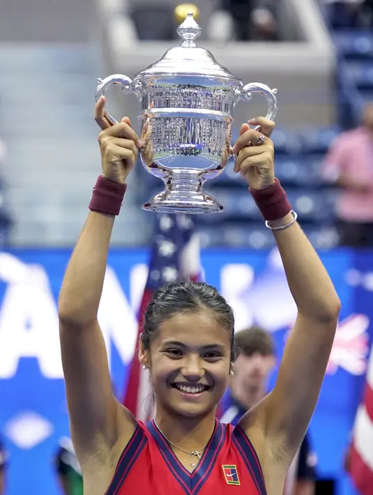Petenis Inggris, Emma Raducanu mengangkat trofi setelah mengalahkan Leylah Fernandez dari Kanada pada final US Open 2021 di Arthur Ashe Stadium, New York, Minggu (12/9/2021). Raducanu menjadi petenis pertama yang berhasil memenangi grand slam lewat babak kualifikasi. (AP Photo/Seth Wenig)