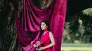 Gaun panjang berwarna fuchsia mencolok yang dikenakan Febby memiliki potongan anggun dan warna yang senada dengan dekorasi. [@terralogical @leurafilm].