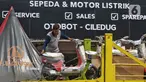 Pekerja tengah menurunkan sepeda motor listrik yang akan di jual di shorum di Tangerang, Banten, Kamis (27/7/2023). (Liputan6.com/Angga Yuniar)