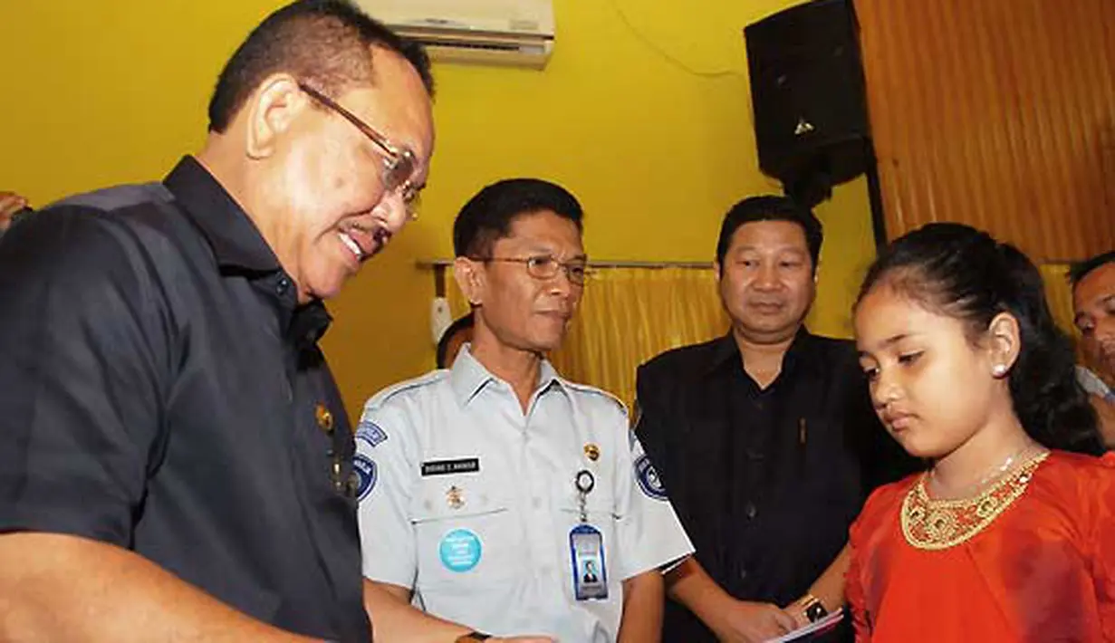 Bupati Aceh Tenggara Hasanuddin (kiri) menyerahkan santunan kepada Silviana Aisyah, ahli waris korban kecelakaan pesawat NBA Cassa 212, di Kutacane,Aceh Tenggara, Rabu (5/10). (Antarafoto)