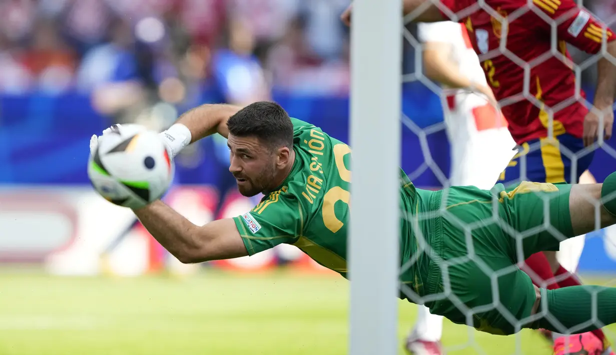 Kiper Timnas Spanyol, Unai Simon berjibaku menghalau bola dari ancaman pemain Timnas Kroasia pada laga Grup B Euro 2024 di Olympiastadion, Berlin, Jeman, Sabtu (15/6/2024). (AP Photo/Ebrahim Noroozi)