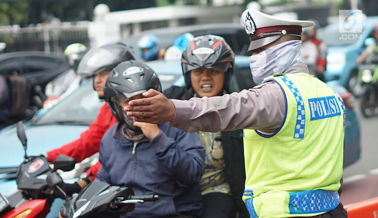 Polisi memberi arahan pada pengendara motor di sekitar lokasi pengalihan arus lalu lintas di Jalan Medan Merdeka Timur, Jakarta, Jumat (14/6/2019). Pengalihan arus dilakukan di sejumlah titik menuju Gedung Mahkamah Konstitusi terkait sidang sengketa Pilpres 2019. (Liputan6.com/Immanuel Antonius)