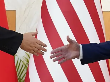 Presiden AS Joe Biden (kanan) dan Presiden China Xi Jinping berjabat tangan sebelum pertemuan mereka di sela-sela pertemuan puncak G20 di Nusa Dua, di Bali, Senin (14/11/2022). Ini merupakan jabat tangan dan tatap muka langsung perdana antara keduanya sejak Biden menjadi Presiden AS dua tahun lalu. (AP/Alex Brandon)