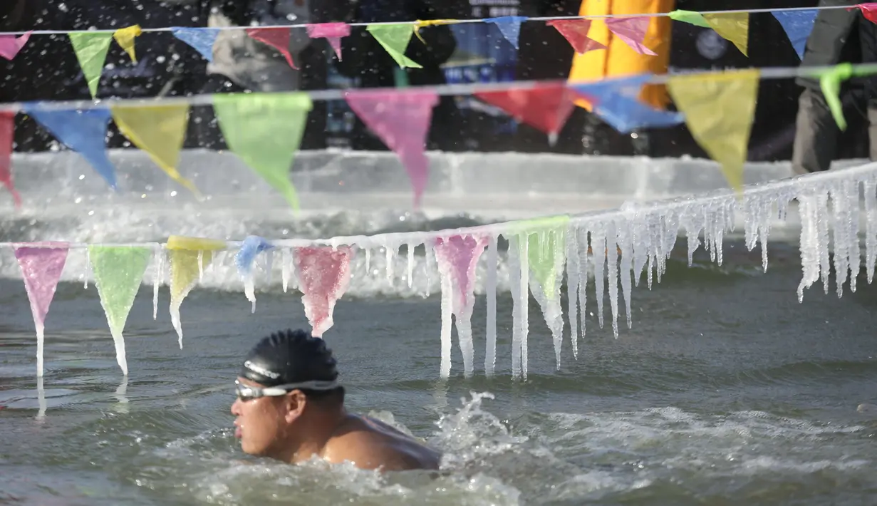Peserta ambil bagian dalam Kompetisi Renang Es Harbin di Sungai Songhua yang membeku di Provinsi Heilongjiang, China, Senin (5/1/2016). Acara ini diselengarakan dalam rangka pembukaan Harbin International Ice and Snow Sculpture Festival (REUTERS/Aly Song)