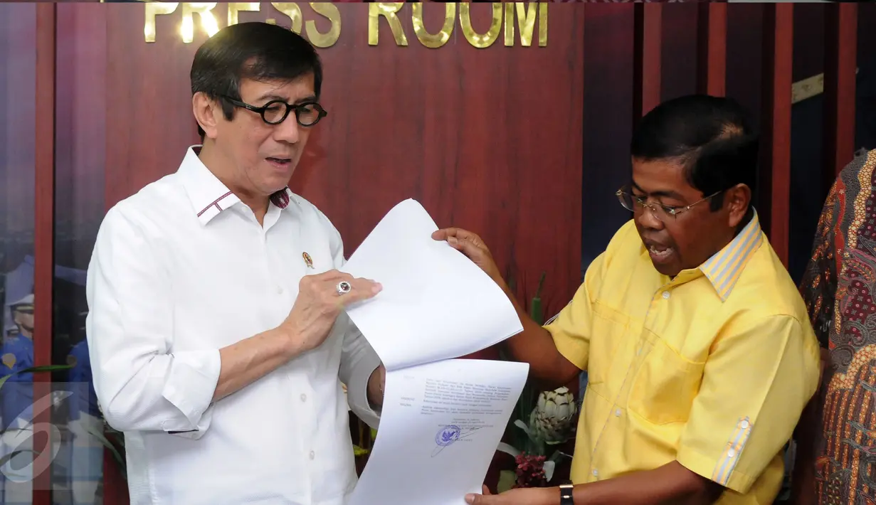Menkumham, Yasonna H Laoly (kiri) bersama Sekjen Partai Golkar Munas Bali, Idrus Marham memperlihatkan SK Pengesahan Komposisi dan Personalia Pengurus DPP Partai Golkar 2014-2019 di Jakarta, Selasa (26/4/2016). (Liputan6.com/Helmi Fithriansyah)