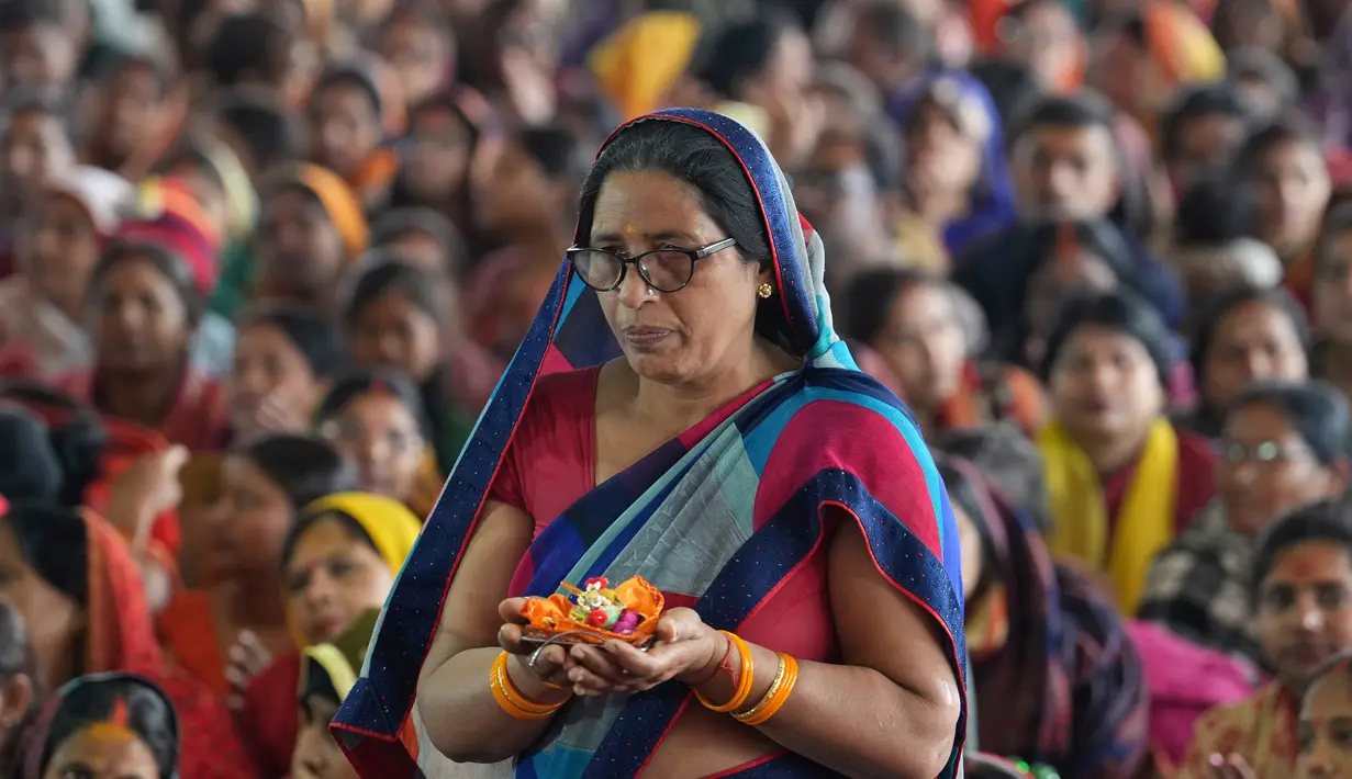 Umat Hindu mendengarkan seorang pemimpin agama Festival Magh Mela di Sangam, pertemuan Sungai Gangga - Sungai Yamuna, Prayagraj, Uttar Pradesh, India, 31 Januari 2023. Ratusan ribu peziarah Hindu diperkirakan akan berenang dalam pertemuan tersebut, berharap bisa menghapus dosa selama festival sebulan penuh. (AP Photo/Rajesh Kumar Singh)