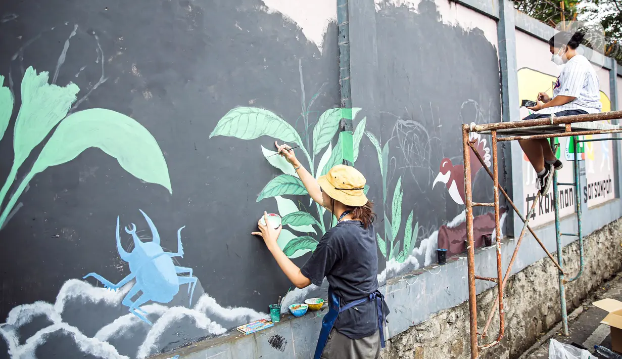 Seniman menyelesaikan pembuatan mural di kawasan Ragunan, Jakarta, Kamis (29/9/2022). Mural-mural tersebut menceritakan Jakarta sebagai Ibu Kota dengan berbagai latar belakang masyarakat yang mencintai alam. (Liputan6.com/Faizal Fanani)
